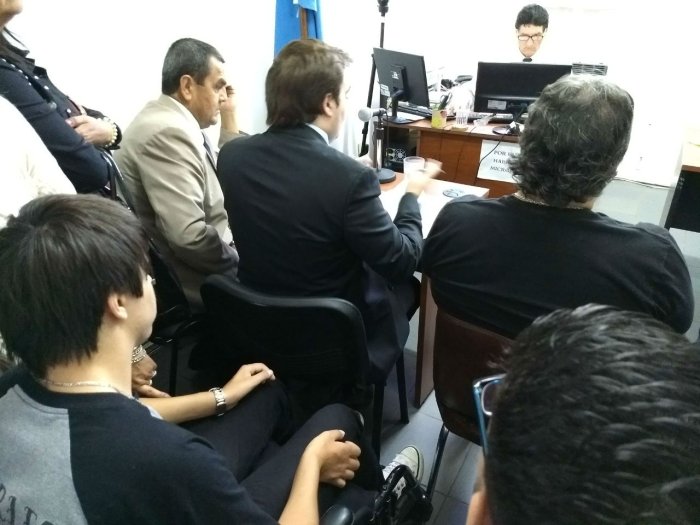 Bruno Escobar escuch&oacute; atentamente la audiencia, con Pietrantueno delante.