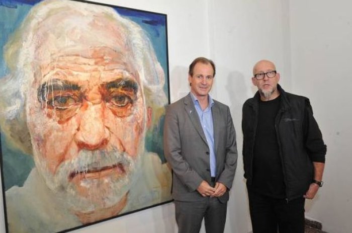Bordet con el artista Julio Lavall&eacute;n, con el retrato de Alonso a su lado.