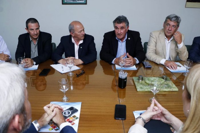 Carlos Achetoni, presidente de CRA, habla ante la atenta mirada del entrerriano Frigerio.