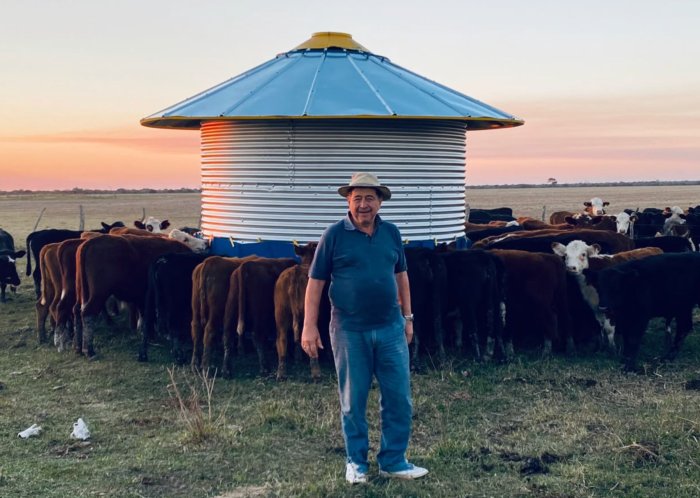 Santiago Castillo en el establecimiento San Pedrito, detr&aacute;s un lote de terneros comiendo en un silo de autoconsumo.