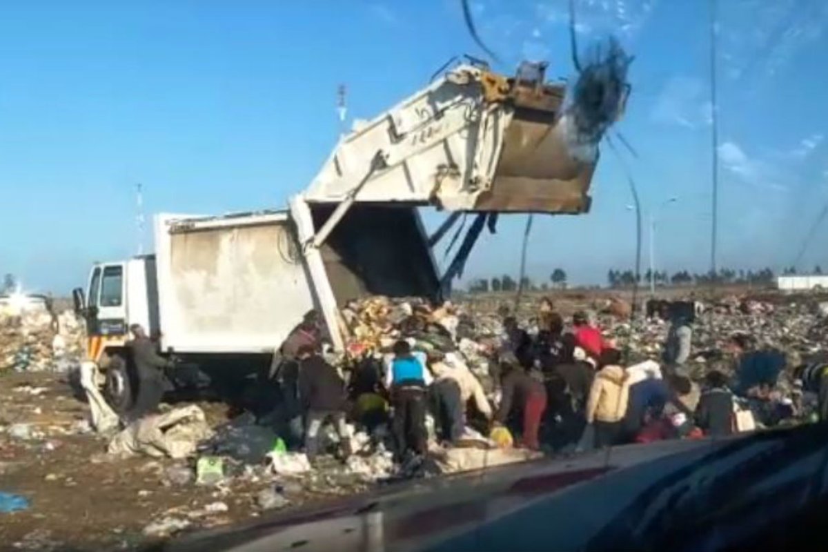 Llega el basurero y se apuran por descargarlo.