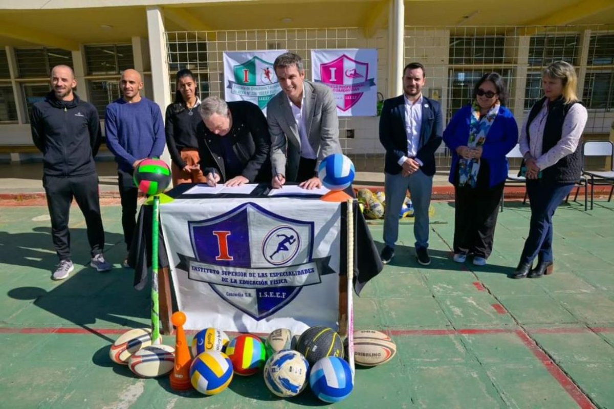 Cresto y Legaretta firmando el acuerdo.
