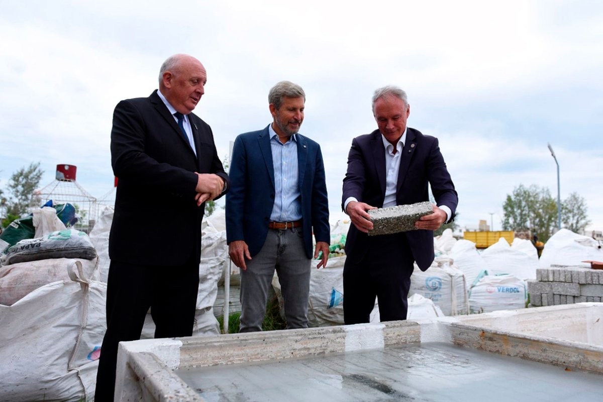Schneider con el ladrillo PET a usar en la obra.