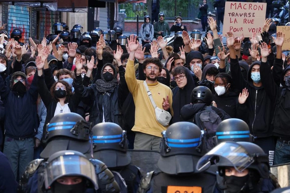 El cartel de los manifestantes dice: &laquo;Macron cruce la calle para ver&raquo;.